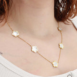 Collier en acier inoxydable doré et trèfle blanc nacré en émail.